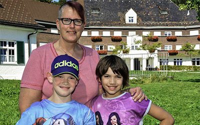 Timo (links) und seine Schwester Sina mit ihrer Mutter vor der Prinz-Luitpold-Klinik in Schweidegg. Foto: kna-bild